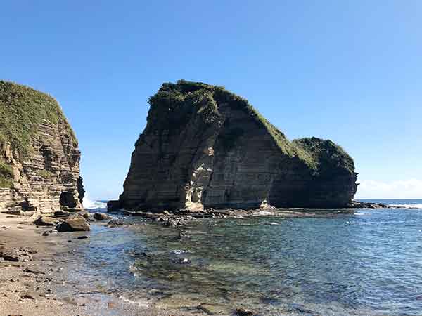 毛戸岬の大きな岩と透明の海と砂浜